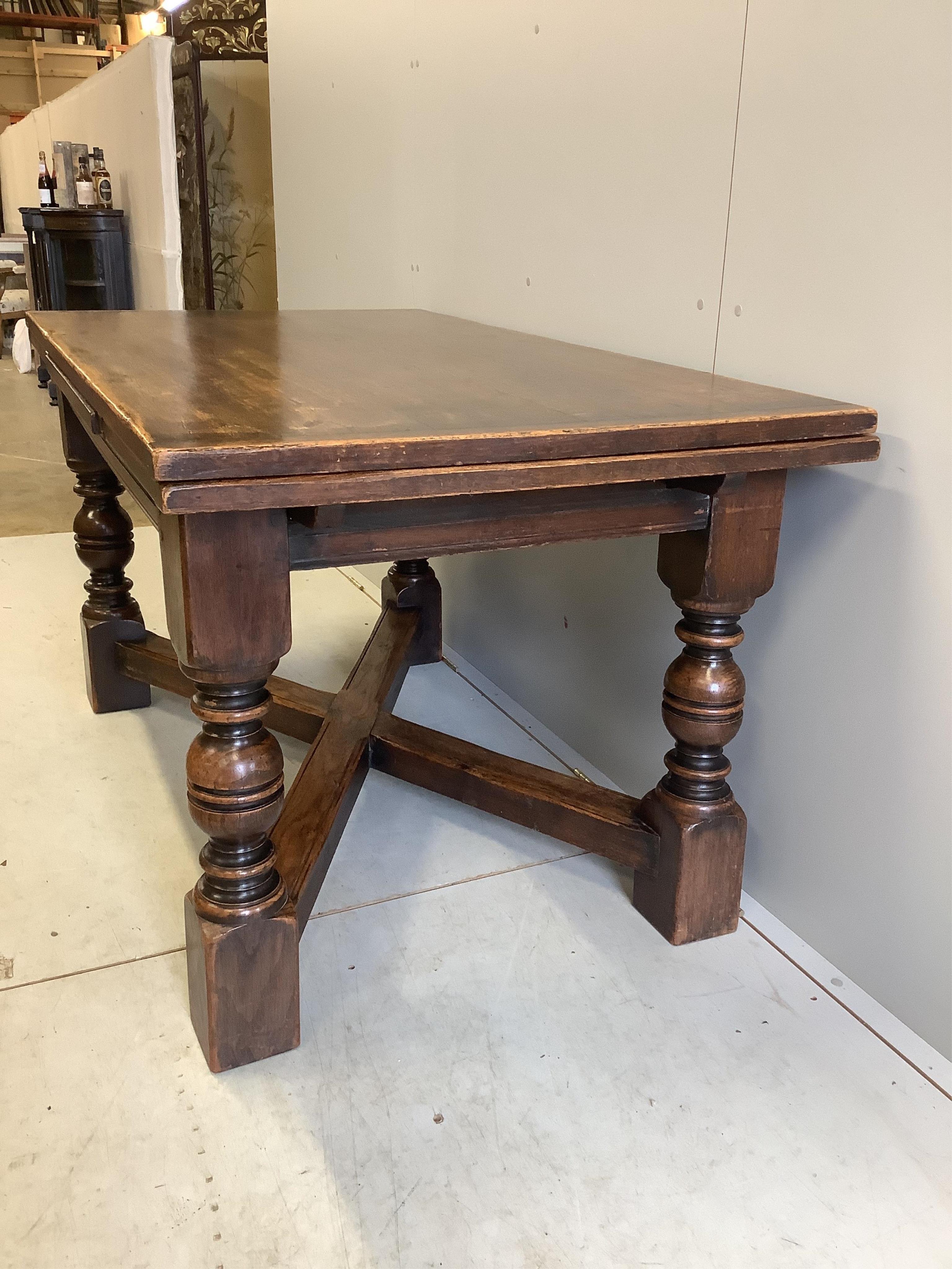 An 18th century style rectangular oak draw leaf refectory dining table, width 244cm extended, depth 85cm, height 79cm together with seven caned oak dining chairs, two with arms. Condition - fair to good